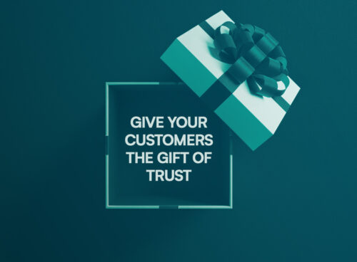 A teal and white Christmas gift box against a teal background. Inside the box is a message: “Give your customers the gift of trust.”