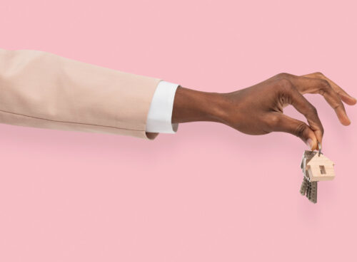 A hand holding house keys against a pink background, symbolizing secure and verified rental transactions.